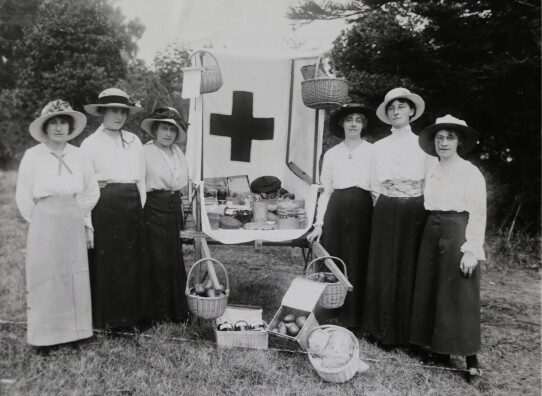 A group of early 20th century women standing with baskets for sale