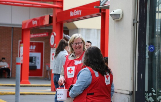 Kerry Nickels wearing a fundraising bib and holding a donation bucket