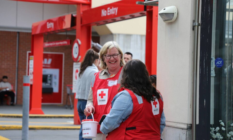 Kerry Nickels wearing a fundraising bib and holding a donation bucket