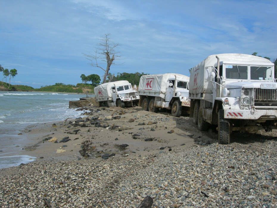 Trucks driving alongside a river