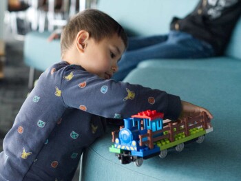 Child plays with toy train