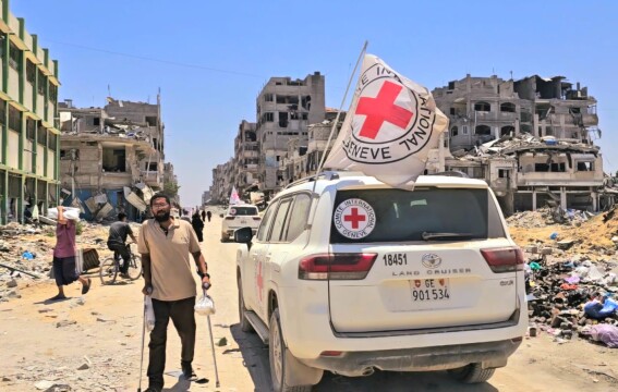 A man using crutches next to an ICRC vehicle