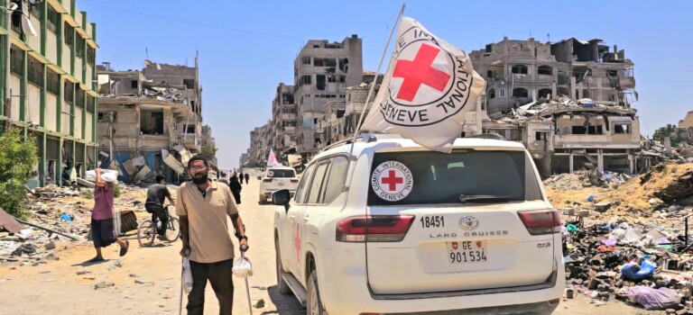 A man using crutches next to an ICRC vehicle