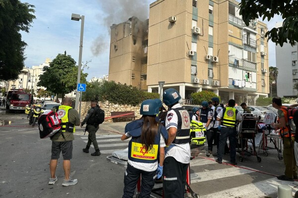 Paramedics outside a building which has been hit by explosive ordnance. 